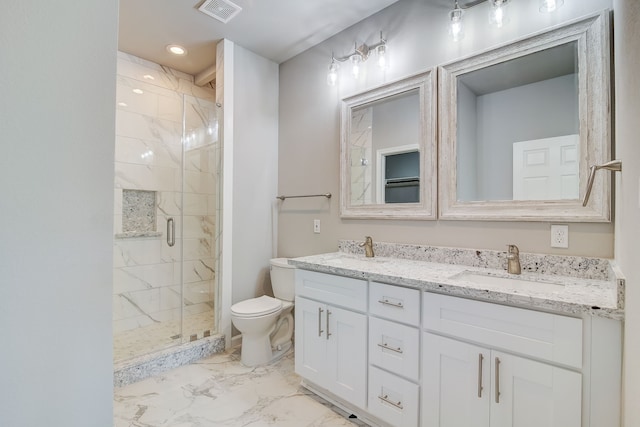 bathroom featuring vanity, a shower with shower door, and toilet