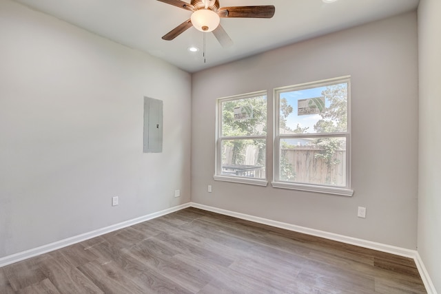 empty room featuring hardwood / wood-style floors, electric panel, and ceiling fan