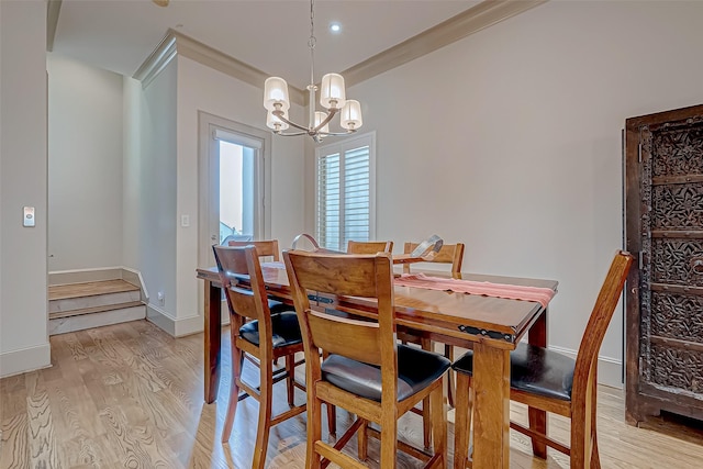 dining space featuring a notable chandelier, crown molding, and light hardwood / wood-style flooring