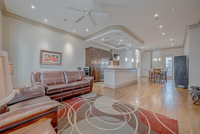 living room featuring ceiling fan with notable chandelier, ornamental molding, and light hardwood / wood-style flooring