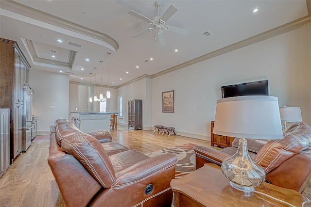 living room featuring ornamental molding, ceiling fan with notable chandelier, and light wood-type flooring