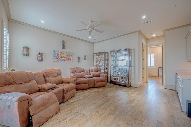 living room with light wood-type flooring, ceiling fan, and crown molding