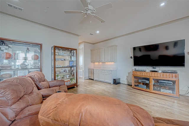 living room featuring ceiling fan, crown molding, and light hardwood / wood-style flooring