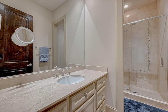 bathroom with a shower with door and vanity