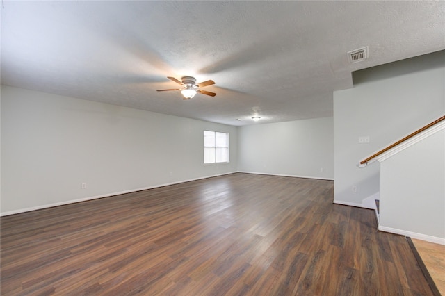 spare room featuring ceiling fan, dark wood-type flooring, and a textured ceiling