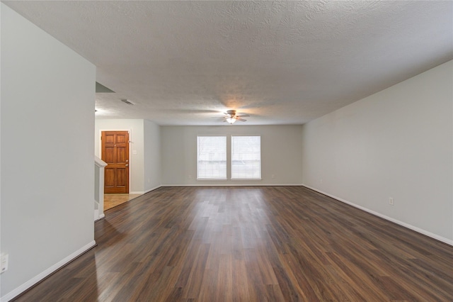 spare room featuring dark hardwood / wood-style floors, ceiling fan, and a textured ceiling