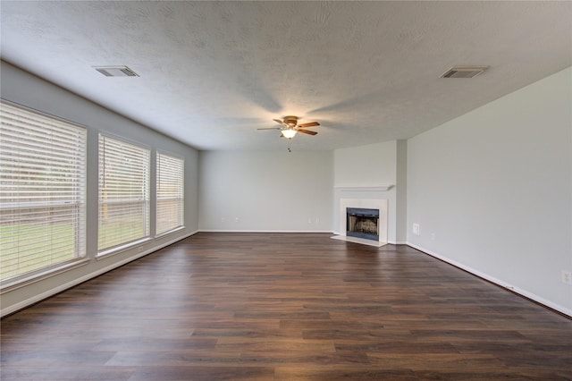 unfurnished living room featuring a textured ceiling, ceiling fan, and dark wood-type flooring