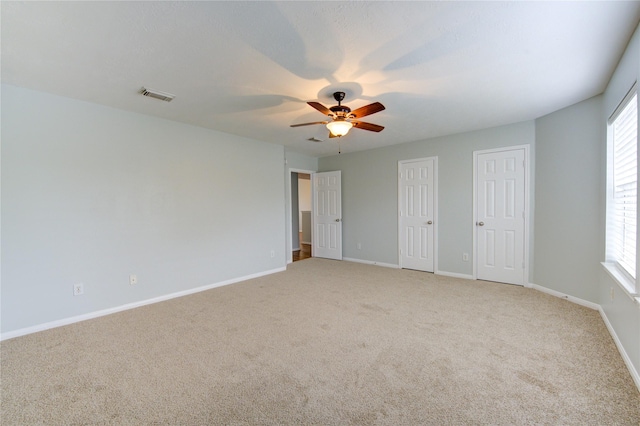 unfurnished bedroom with multiple windows, ceiling fan, and light carpet