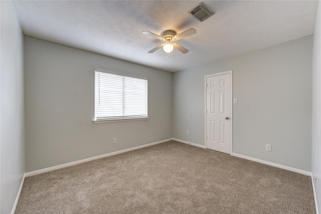 unfurnished room featuring ceiling fan, light colored carpet, and a textured ceiling