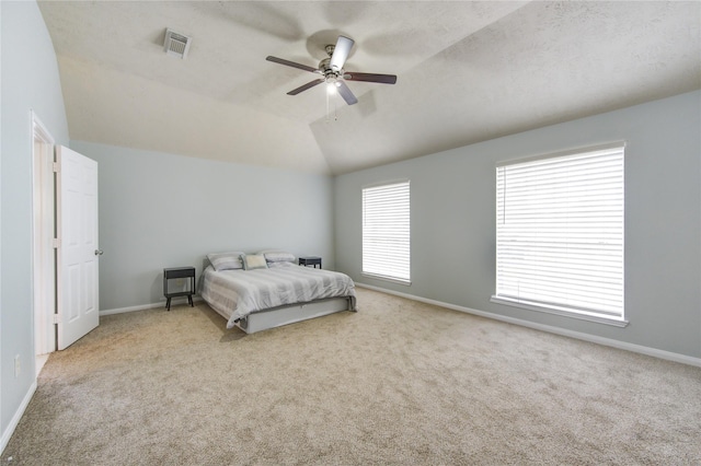 carpeted bedroom featuring ceiling fan, lofted ceiling, and a textured ceiling