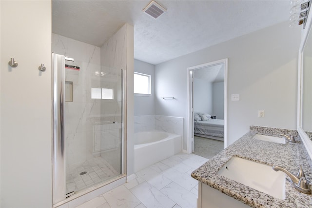 bathroom featuring a textured ceiling, vanity, and shower with separate bathtub