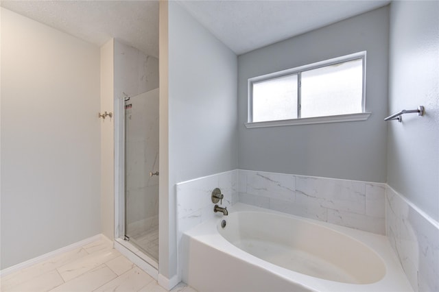 bathroom featuring a textured ceiling and independent shower and bath