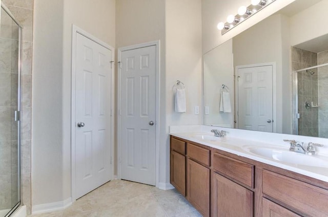 bathroom with tile patterned flooring, vanity, and a shower with door