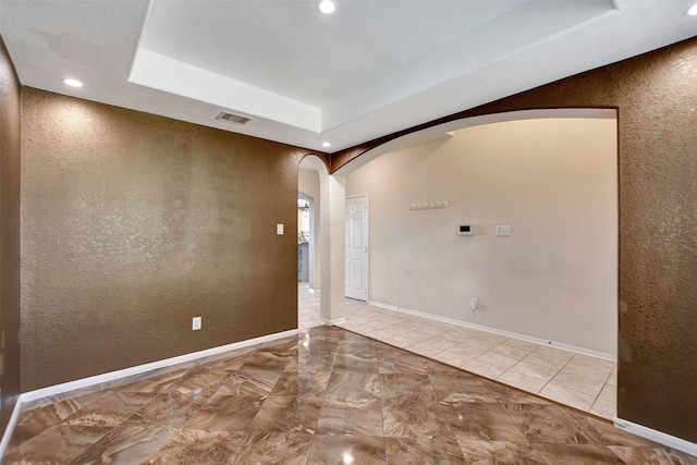 unfurnished room featuring a raised ceiling