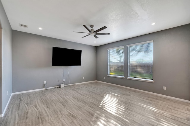 unfurnished living room with ceiling fan, light hardwood / wood-style floors, and a textured ceiling