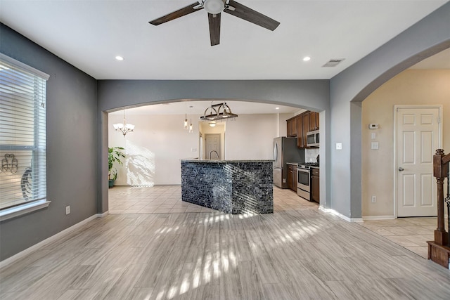 living room featuring ceiling fan with notable chandelier and light wood-type flooring