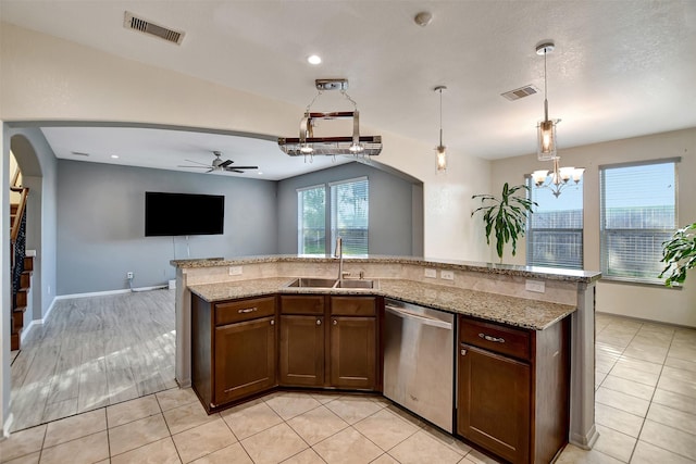 kitchen with pendant lighting, dishwasher, ceiling fan with notable chandelier, sink, and light stone countertops