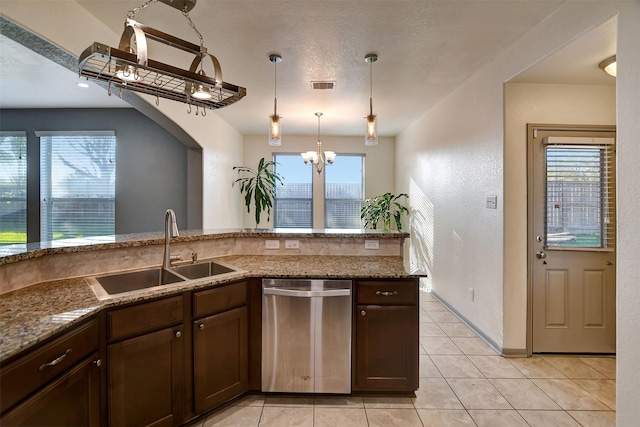 kitchen with stainless steel dishwasher, plenty of natural light, sink, and stone counters