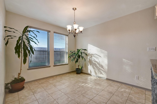 empty room featuring light tile patterned flooring and a notable chandelier