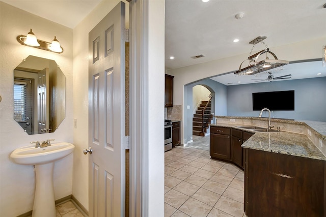 bathroom featuring tile patterned flooring, ceiling fan, decorative backsplash, and sink