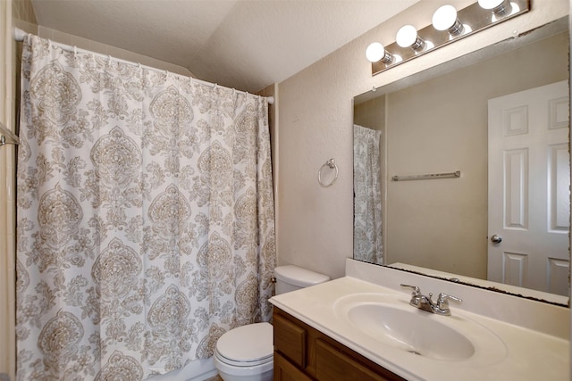 bathroom featuring vanity, toilet, and vaulted ceiling