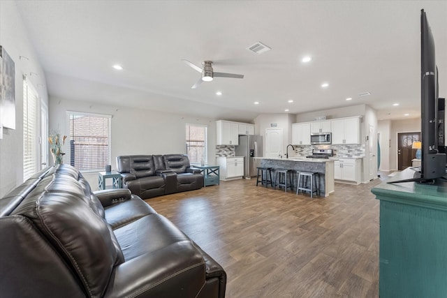 living room with ceiling fan, wood-type flooring, and sink