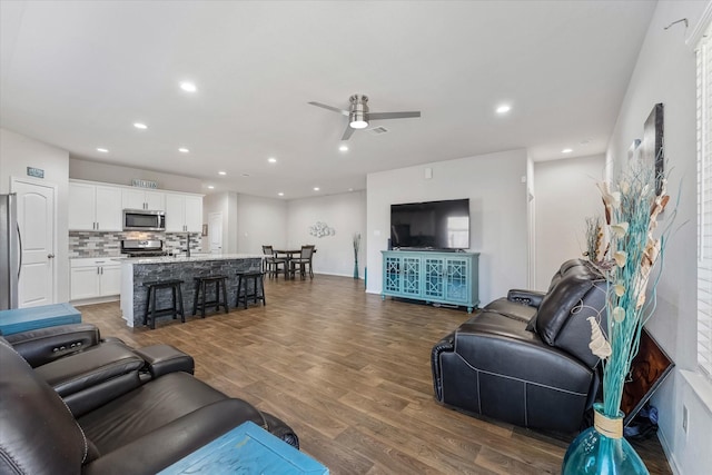 living room with ceiling fan and dark hardwood / wood-style flooring