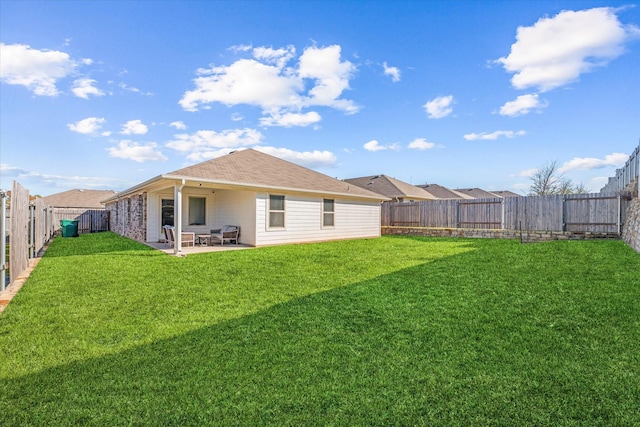 back of house featuring a lawn and a patio area