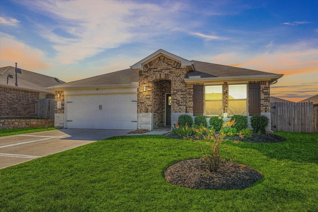 ranch-style home with a garage and a yard