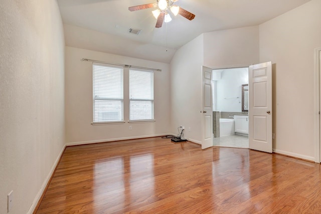 spare room featuring lofted ceiling, light hardwood / wood-style flooring, and ceiling fan