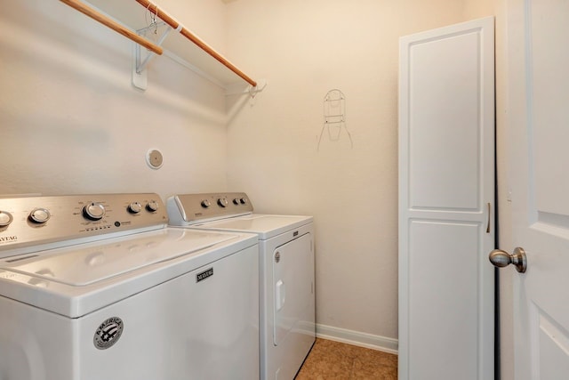 clothes washing area featuring washer and dryer and light tile patterned floors