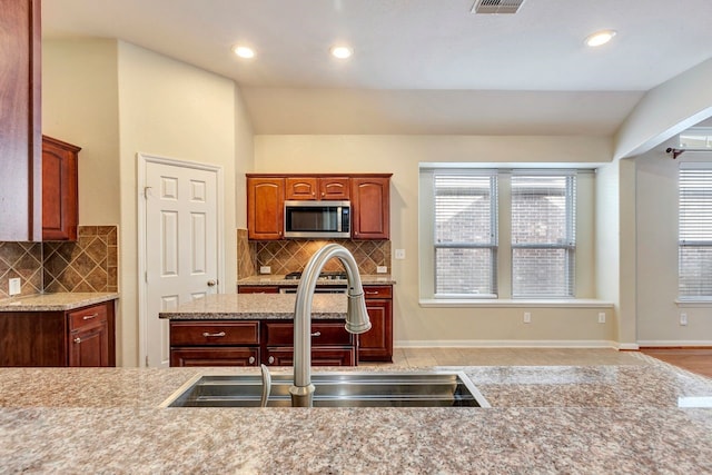 kitchen with lofted ceiling, sink, backsplash, and light tile patterned floors