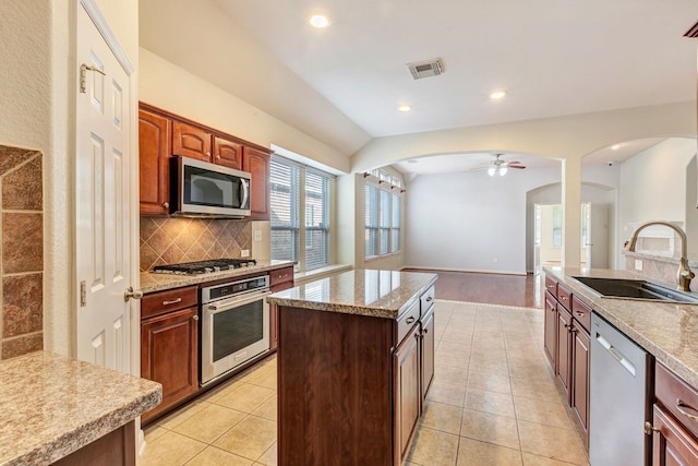 kitchen featuring sink, light tile patterned floors, backsplash, and appliances with stainless steel finishes