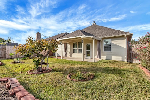 rear view of house with a yard and a patio area