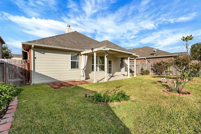 back of property with a yard and a patio area