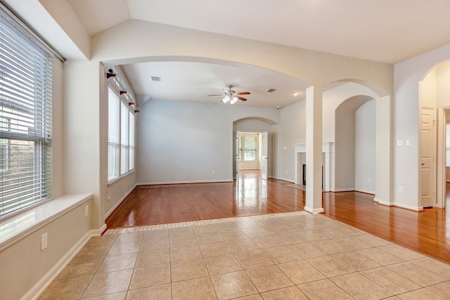 tiled spare room featuring ceiling fan and vaulted ceiling