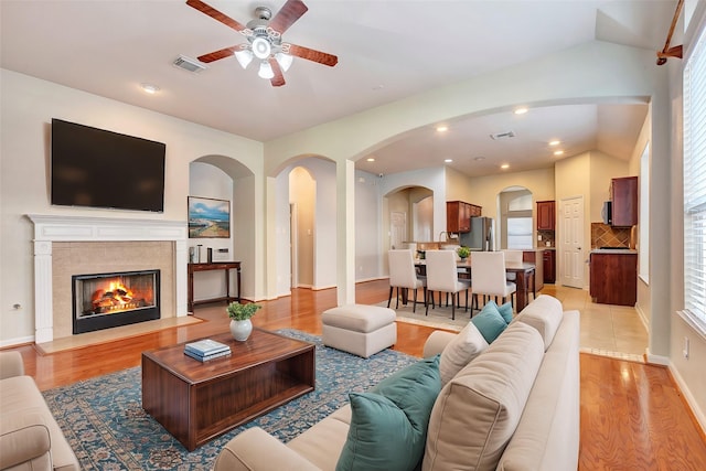 living room featuring vaulted ceiling, ceiling fan, and light hardwood / wood-style floors