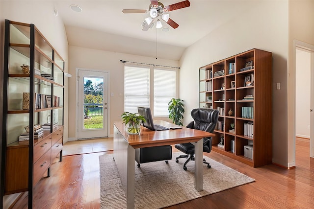 home office with lofted ceiling, light hardwood / wood-style flooring, and ceiling fan