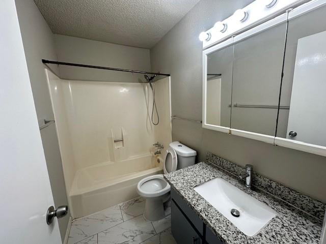 full bathroom with a textured ceiling, vanity,  shower combination, and toilet