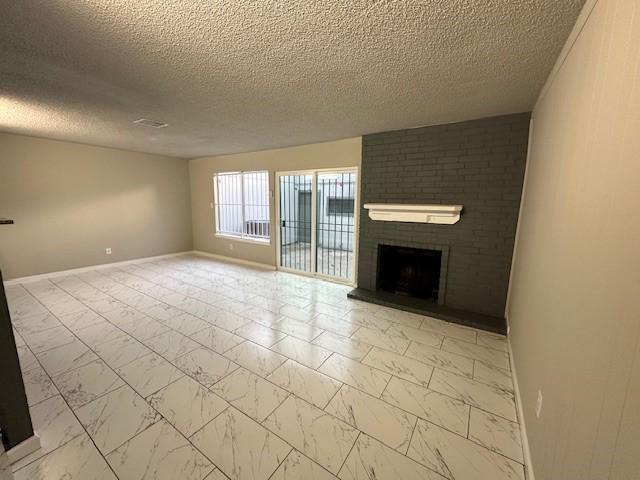 unfurnished living room featuring a textured ceiling and a fireplace