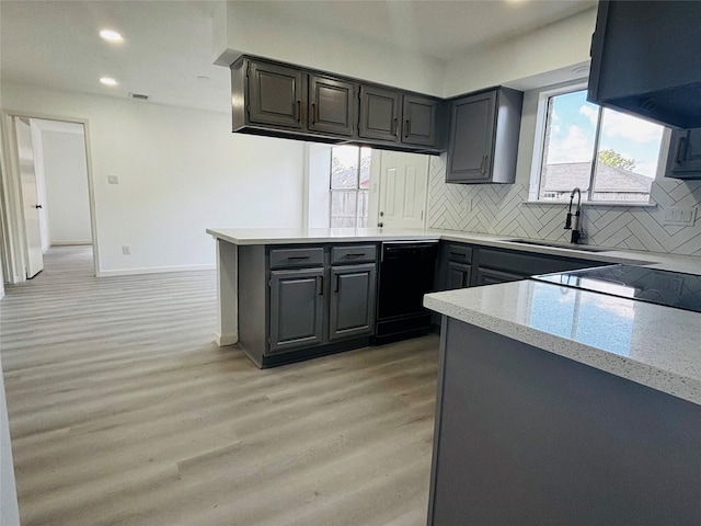 kitchen with tasteful backsplash, gray cabinets, dishwasher, and light hardwood / wood-style floors