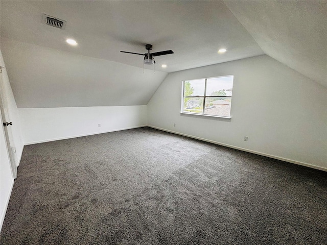 bonus room with a textured ceiling, ceiling fan, dark carpet, and lofted ceiling