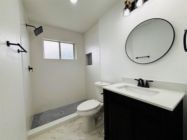 bathroom featuring tiled shower, vanity, and toilet