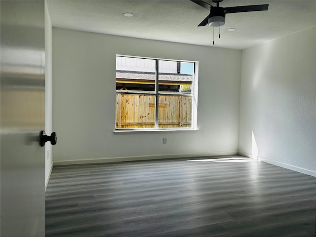 spare room featuring ceiling fan and dark hardwood / wood-style floors