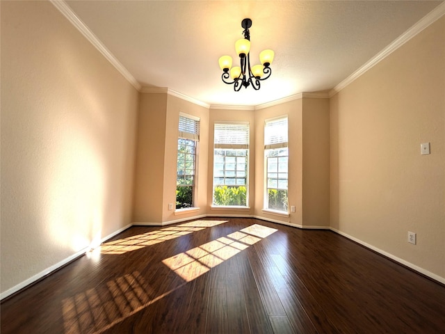 spare room featuring a chandelier, dark wood-type flooring, and ornamental molding