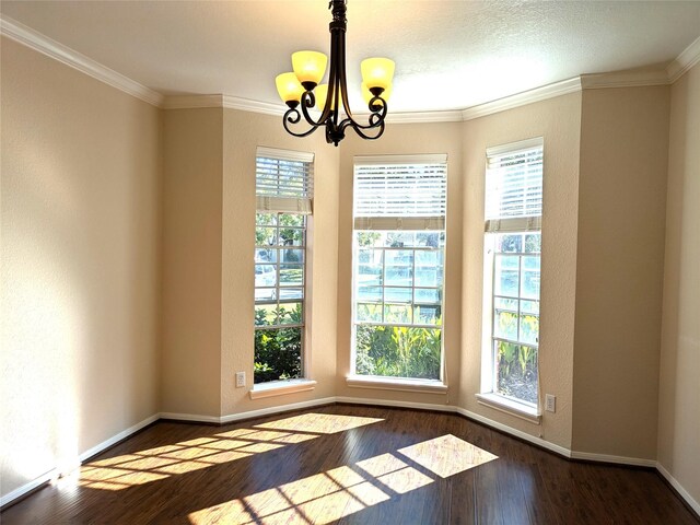 unfurnished room with a chandelier, crown molding, plenty of natural light, and dark wood-type flooring