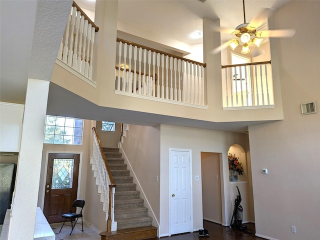 entrance foyer with ceiling fan and a high ceiling