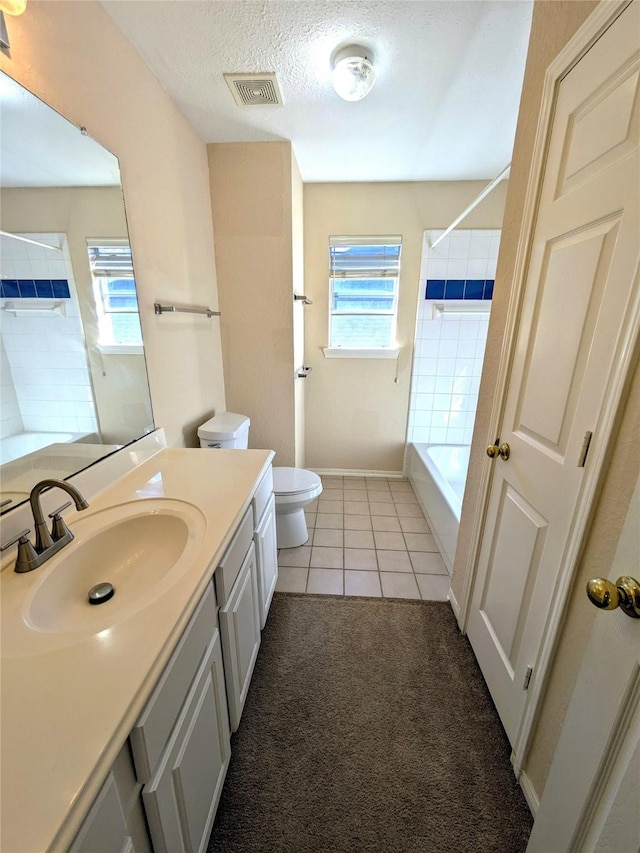 full bathroom featuring tile patterned flooring, bathing tub / shower combination, a textured ceiling, toilet, and vanity