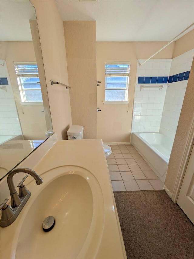 full bathroom with tile patterned floors, toilet, a healthy amount of sunlight, and sink