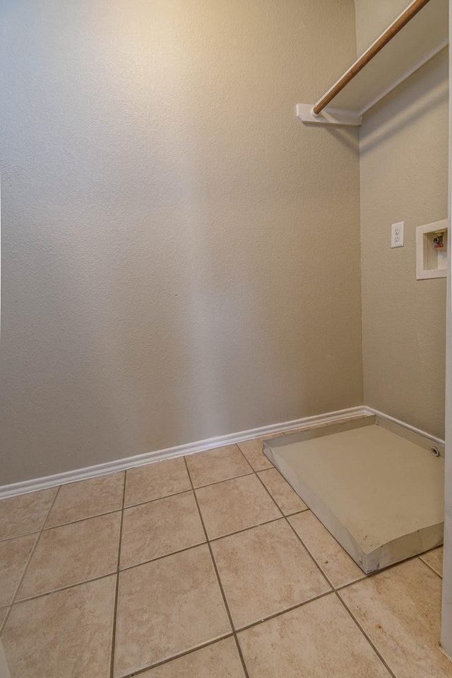 clothes washing area featuring light tile patterned floors and washer hookup